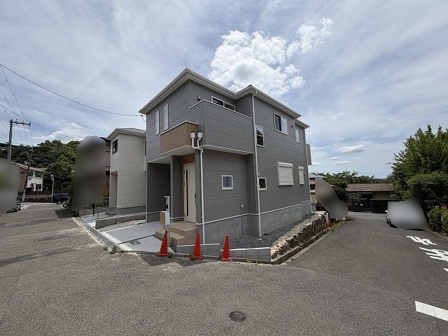 高槻市大和1丁目　新築一戸建　1号地  閑静な住宅街に位置する、スタイリッシュな外観の二階建て住宅。広々とした道路に面し、開放感があります。